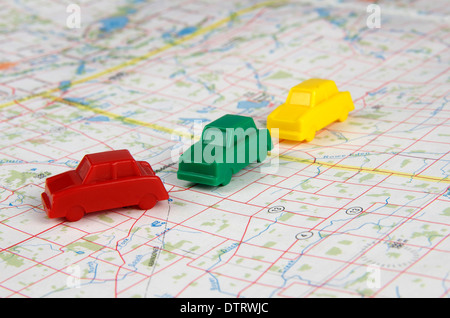 Miniatur-Autos von rot, grün und gelb, die Reisen über eine Karte in einer Fahrgemeinschaft Mode. Stockfoto
