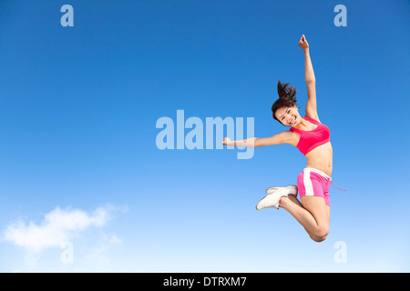 glückliche junge Asiatin, die in den Himmel springen Stockfoto