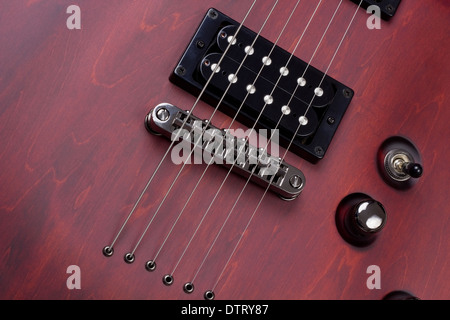 Rote retro Vintage hölzernen Festkörper elektrische Massenproduktion Gitarre mit Saiten und Pickups Hintergrund. Selektive Kunst Fokus Stockfoto