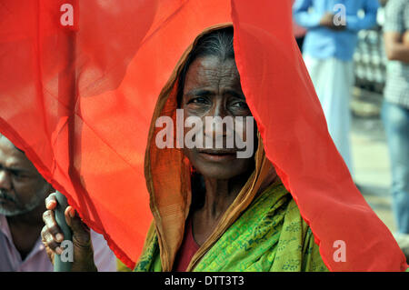 Dhaka, Bangladesch. 24. Februar 2014. Eine Frau hält eine rote Fahne, wenn Angehörige von Opfern des Rana Plaza eine Demonstration in Savar, am Stadtrand von Dhaka bereitstellen. Die Überlebenden und ihre Angehörigen, die diejenigen am Montag das zehnmonatige Jubiläum Bangladeshs größte industrielle Tragödie, während viele Familien ausdrückliche Wut und Ärger wegen fehlender angemessene Hilfe markiert. Rana Plaza, einem achtstöckigen Gebäude, fünf Bekleidungsfabriken, zerbröckelte in einem Zement-Grab am 24. April 2013 in Savar am Rande der Hauptstadt Dhaka, tötet mehr als 1.130 Menschen, zumeist Arbeitskräfte. (Xi Credit: Xinhua/Alamy Live-Nachrichten Stockfoto