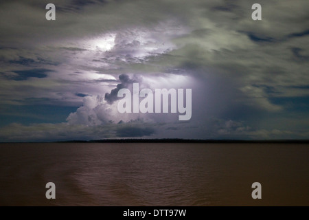 Dramatische Wetterleuchten unter Gewitterwolken leuchtet am Nachthimmel über dem Amazonas, Amazonas, Brasilien Stockfoto