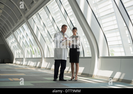 Arzt und Geschäftsfrau im Korridor im Gespräch Stockfoto