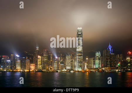 Hong Long am Wasser in der Nacht mit Laser projiziert Lichtstrahlen in einem nebligen grau-braunen Winter Himmel an die nächtliche Lasershow Stockfoto