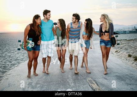 Freunde, die zusammen am Strand spazieren Stockfoto