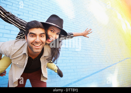 Indische paar Huckepack entlang der Mauer Stockfoto