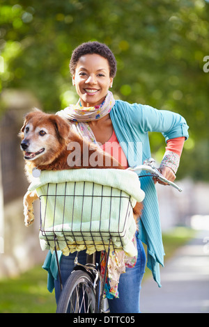 Schwarze Frau mit Hund im Fahrradkorb Stockfoto