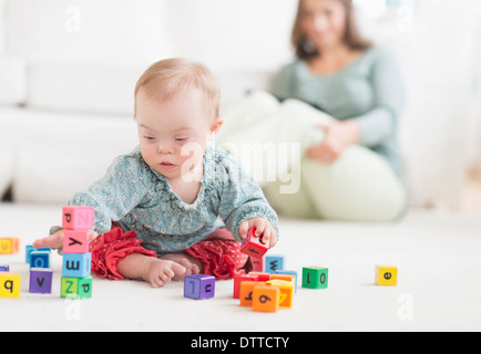Kaukasische Mädchen mit Down-Syndrom mit Blöcke spielen Stockfoto