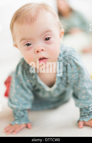 Kaukasische Mädchen mit Down-Syndrom, kriechen Stockfoto