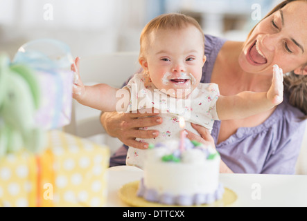 Kaukasische Mutter und Babymädchen mit Down-Syndrom feiert Geburtstag Stockfoto