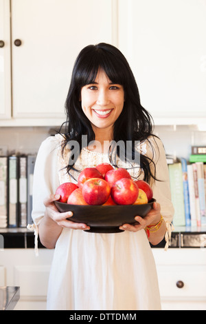 Frau mit Obstschale in der Küche Stockfoto