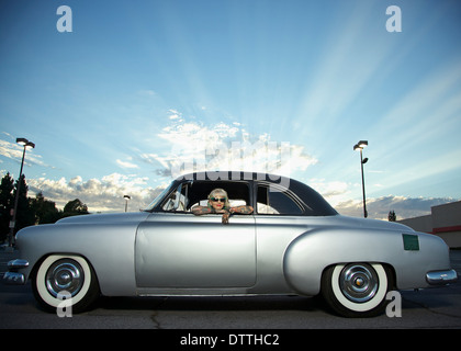 Frau mit Tattoos aus Fenster 1951 Chevy gelehnt Stockfoto