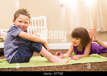 Kaukasische Mädchen Malerei Bruder Zehen Stockfoto