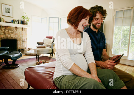 Schwanger kaukasischen paar mit digital-Tablette Stockfoto