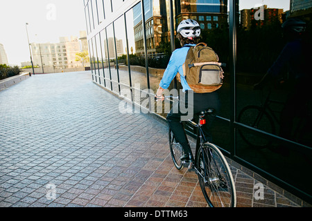 Kaukasische Geschäftsmann Reiten Fahrrad außerhalb Gebäude Stockfoto