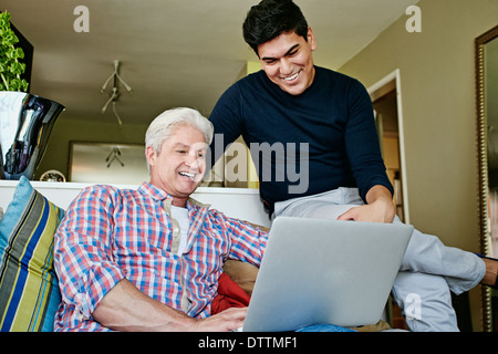 Homosexuelles Paar mit Laptop im Wohnzimmer Stockfoto