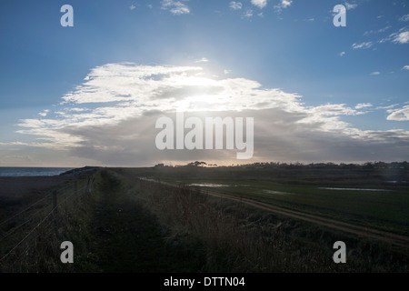 Frontale Wolken über den Himmel, die Sonne am Bawdsey, Suffolk, England Ausblocken Stockfoto