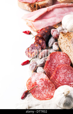 Satz von Schinken und Salami Wurst serviert mit frischem Brot, Knoblauch und red hot Chili Peppers auf weiß Stockfoto