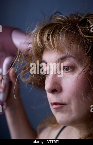 eine Frau ihr Haar trocknen Stockfoto