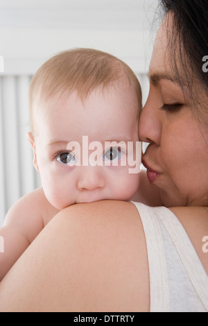 Mutter küssen Hispanic Babyjungen Wange Stockfoto