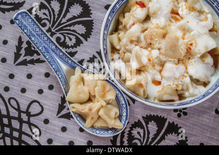 Traditionellen türkischen Ravioli in einer Schüssel auf einem dekorativen Tischdecke-Hintergrund Stockfoto