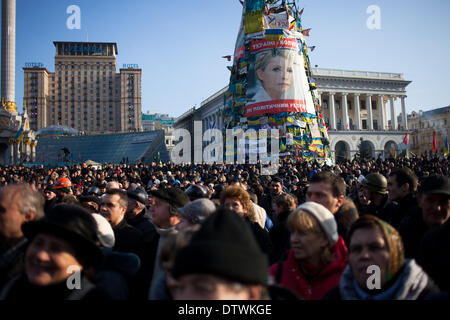 Kiew, Ukraine. 21. Februar 2014. Menschen versammeln sich in Unabhängigkeit quadratisch mit neben einem Poster von ehemalige ukrainische Premierminister Yulia Tymoshenko hinter als Särge der Anti-Regierungs-Demonstrator im gestrigen Auseinandersetzungen mit der Polizei getötet ankommen auf dem Platz. © Emeric Fohlen/NurPhoto/ZUMAPRESS.com/Alamy Live-Nachrichten Stockfoto