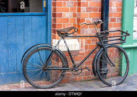 Alten Stil Fahrrad angekettet an ein Abflussrohr eine rote Wand bei Blists Hill viktorianischen Stadt Telford England gelehnt Stockfoto