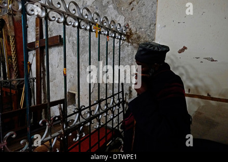 Eine Äthiopische Orthodoxe Christliche Priester an den äthiopischen Abschnitt der Kirche des Heiligen Grabes in Jerusalem Israel am 24. Februar 2014. Die Äthiopier haben keine Eigenschaft in der Kirche des Heiligen Grabes, nur die Zugriffsrechte; aber sie ein kleines Kloster in der Nähe, bekannt als Deir es-Sultan haben Stockfoto