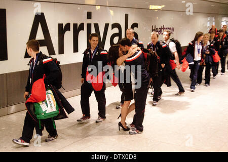 Heathrow-London, UK. 24. Februar 2014. Dave Murdoch Kapitän des Curliing der Herrenmannschaft ist von seiner Frau umarmte, nach der Ankunft am Flughafen Heathrow aus der 2014 Olympischen Winterspiele in Sotschi tragen ihre Goldmedaille Credit: Amer Ghazzal/Alamy Live-Nachrichten Stockfoto