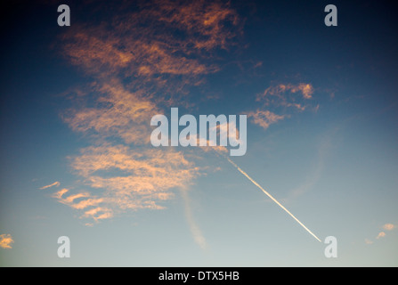 Jet Kondensstreifen und rosa Wolken gegen Sonnenuntergang Himmelblau in Colorado, USA Stockfoto