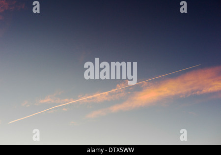 Jet Kondensstreifen und rosa Wolken gegen Sonnenuntergang Himmelblau in Colorado, USA Stockfoto