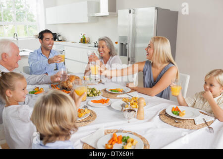 Lächelnde Familie heben ihre Gläser zusammen Stockfoto