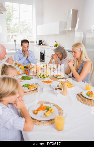 Familie beten vor dem Essen Stockfoto