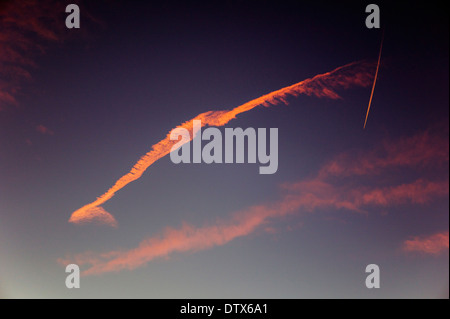 Jet Kondensstreifen und rosa Wolken gegen Sonnenuntergang Himmelblau in Colorado, USA Stockfoto