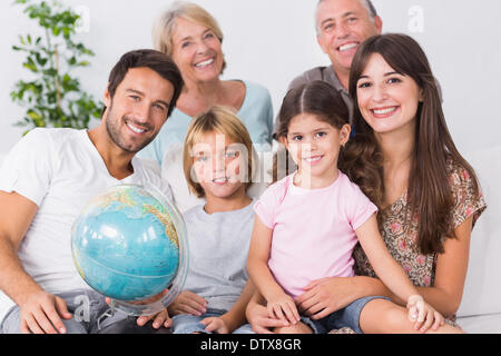 Lächelnde Familie mit Globus Stockfoto