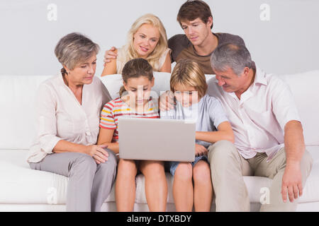 Familie sucht am Laptop auf couch Stockfoto
