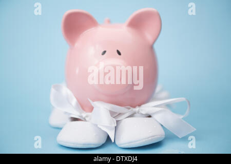 Piggy Bank tragen weiße Babyschuhe Stockfoto