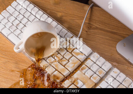 Tasse Tee übergreifen einer Tastatur Stockfoto