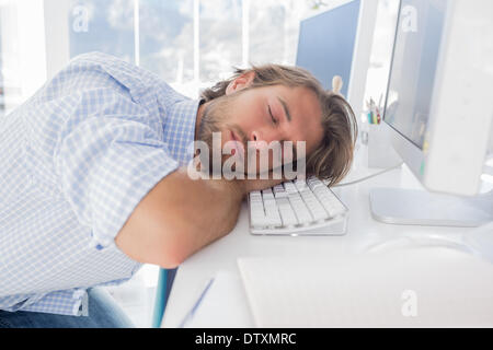 Mann schläft auf seinem Schreibtisch Stockfoto