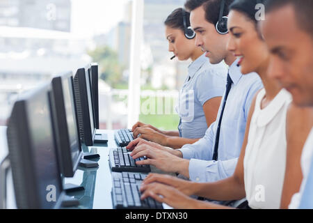 Call-Center-Mitarbeiter arbeiten an Computern Stockfoto