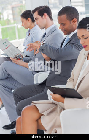 Business-Leute saßen in Linie Stockfoto