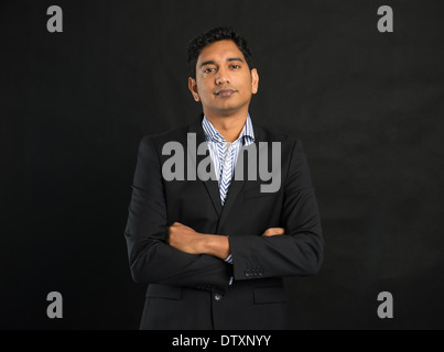 indische Geschäftsmann auf dunklem Hintergrund, gekreuzt arm Stockfoto