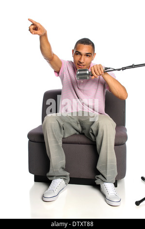 Young African American Vintage Mikrofon sitzt auf dem Sofa Sessel Stockfoto