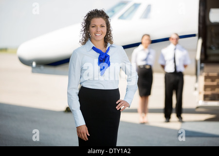 Stewardess mit Hand im Hip stehen am Flughafenterminal Stockfoto