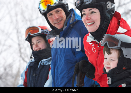 Kaukasische Familie tragen Skiausrüstung im Schnee Stockfoto