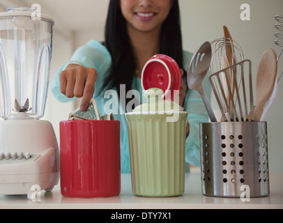 Chinesin, Geld in Einsparungen Glas Stockfoto