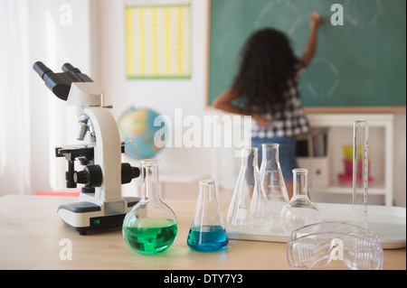 Gemischte Rassen Student schreibt an die Tafel im Klassenzimmer Stockfoto