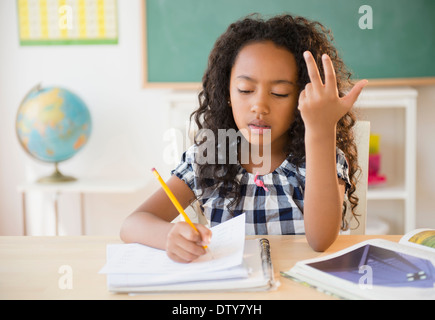 Mischlinge-Student zählt an den Fingern im Klassenzimmer Stockfoto