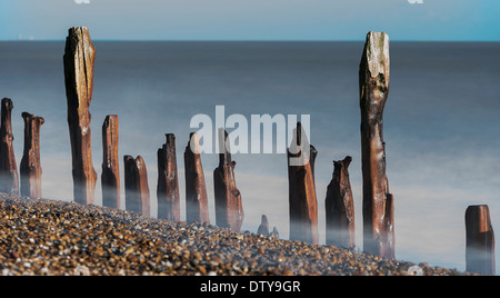 Das Meer wäscht auf den Resten eines längst vergangenen Steg entlang des Strandes von Winchelsea in East Sussex. UK Stockfoto