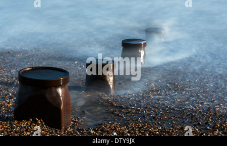 Das Meer wäscht auf den Resten eines längst vergangenen Steg entlang des Strandes von Winchelsea in East Sussex. UK Stockfoto