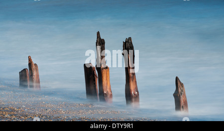 Das Meer wäscht auf den Resten eines längst vergangenen Steg entlang des Strandes von Winchelsea in East Sussex. UK Stockfoto